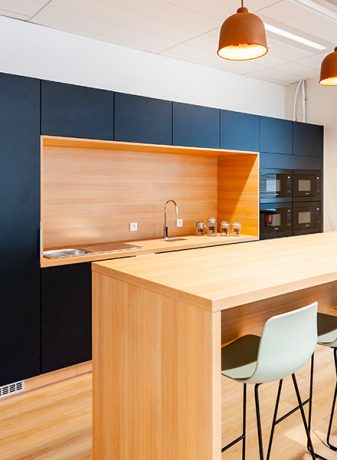 Cuisine moderne équipée d'une table haute Swarm et de tabourets assortis. Cette configuration contemporaine permet des repas informels tout en favorisant les échanges dans un espace fonctionnel et stylé, idéal pour des pauses café ou des discussions rapides.