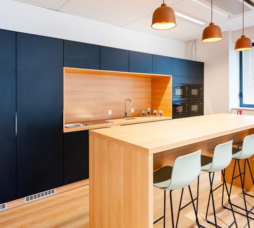 Cuisine moderne équipée d'une table haute Swarm et de tabourets assortis. Cette configuration contemporaine permet des repas informels tout en favorisant les échanges dans un espace fonctionnel et stylé, idéal pour des pauses café ou des discussions rapides.