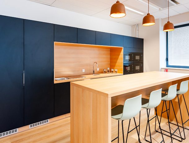 Cuisine moderne équipée d'une table haute Swarm et de tabourets assortis. Cette configuration contemporaine permet des repas informels tout en favorisant les échanges dans un espace fonctionnel et stylé, idéal pour des pauses café ou des discussions rapides.