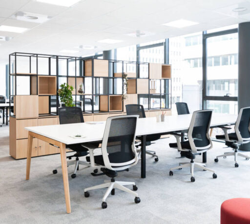 Bureau ouvert équipé de tables Woodesk et de sièges ergonomiques J1 avec un séparateur CORRAL, créant un espace de travail à la fois fonctionnel et ergonomique pour un confort optimal tout au long de la journée.