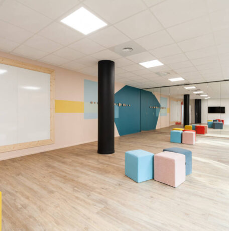 Salle de créativité aménagée avec des porte-manteaux Fixil, des poufs confortables et un tableau, offrant un espace inspirant et fonctionnel pour des sessions de brainstorming.