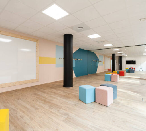 Salle de créativité aménagée avec des porte-manteaux Fixil, des poufs confortables et un tableau, offrant un espace inspirant et fonctionnel pour des sessions de brainstorming.