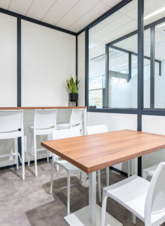Cuisine chez Afyren aménagée avec une table en bois à piètement métal blanc et des chaises Maya blanches, combinant design épuré et fonctionnalité pour un espace de repas convivial.