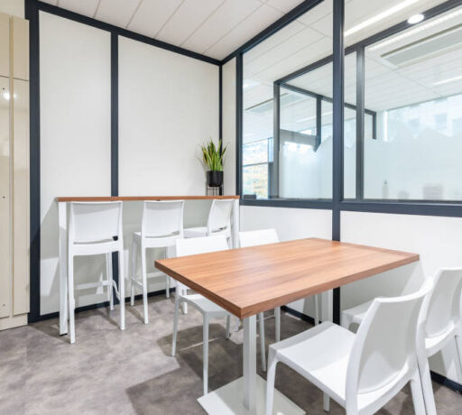 Cuisine chez Afyren aménagée avec une table en bois à piètement métal blanc et des chaises Maya blanches, combinant design épuré et fonctionnalité pour un espace de repas convivial.
