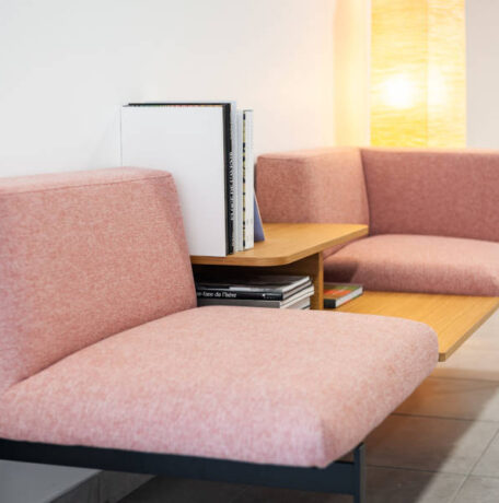 Deux fauteuils confortables disposés avec une table basse intégrée avec des magazines, créant un espace convivial et relaxant pour les pauses et les discussions informelles chez Techtera.