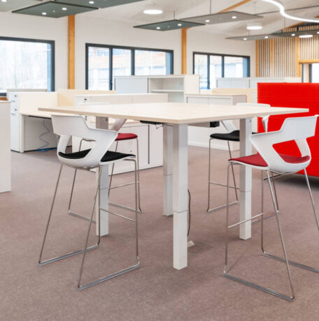Espace de pause avec une table haute et des tabourets Joky à piètement luge, offrant une configuration conviviale pour les repas et les échanges informels.