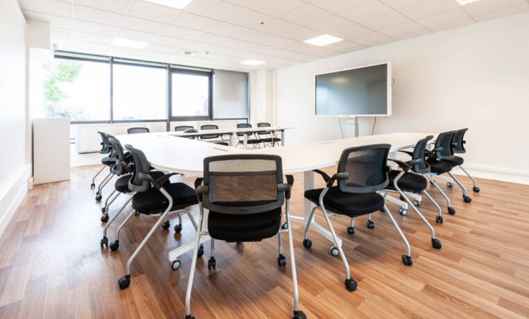 Table de réunion avec des tables modulables et des chaises Birdy, permettant une configuration flexible et un confort optimal pour les sessions de travail en groupe.