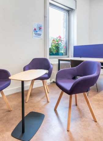 Espace détente dans l'espace de coworking, aménagé avec des chaises rembourrées confortables et une table WiFi, permettant aux utilisateurs de se reposer ou de travailler de manière informelle.