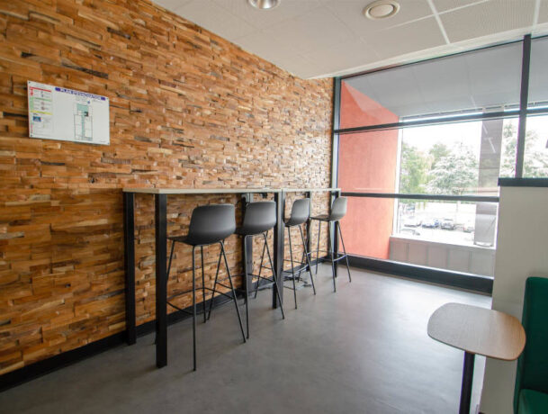 Deuxième espace de travail au CESI Arras équipé d'une table haute et d'un tabouret, fournissant une alternative moderne pour le travail en mode stand-up ou les discussions informelles.