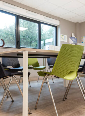 Salle de réunion moderne chez Ginger, équipée d'une grande table centrale et de chaises, conçue pour des réunions et des conférences de groupe.