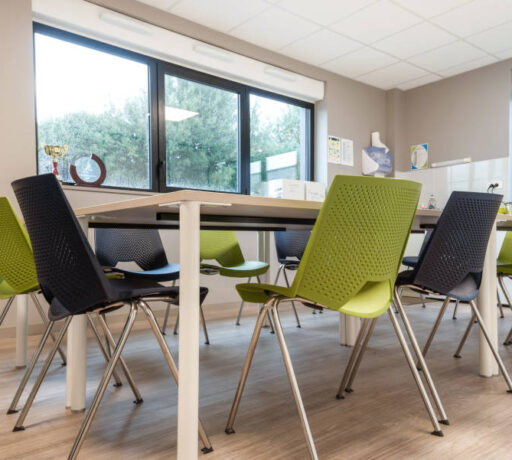 Salle de réunion moderne chez Ginger, équipée d'une grande table centrale et de chaises, conçue pour des réunions et des conférences de groupe.