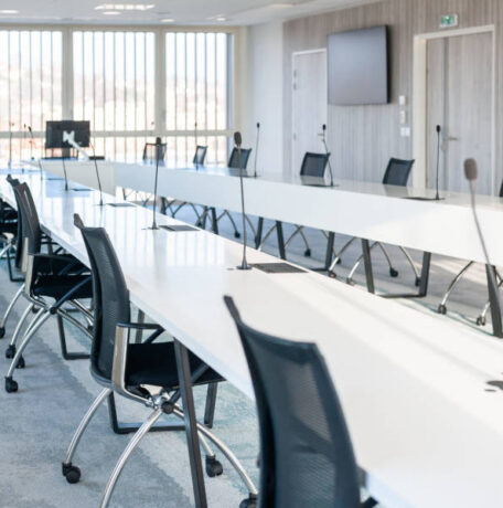 Grande salle de réunion moderne chez OPAC du Rhône, équipée d'une grande table de conférence entourée de chaises ergonomiques, idéale pour les réunions d'équipe et les présentations.