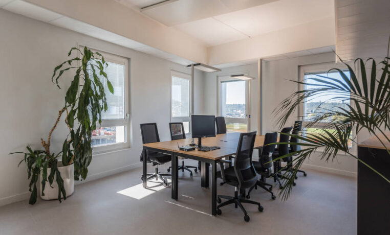 Salle de réunion chez Habitat 76, équipée de plusieurs tables U-DESK et de sièges ergonomiques, offrant un cadre professionnel pour les réunions et les présentations.