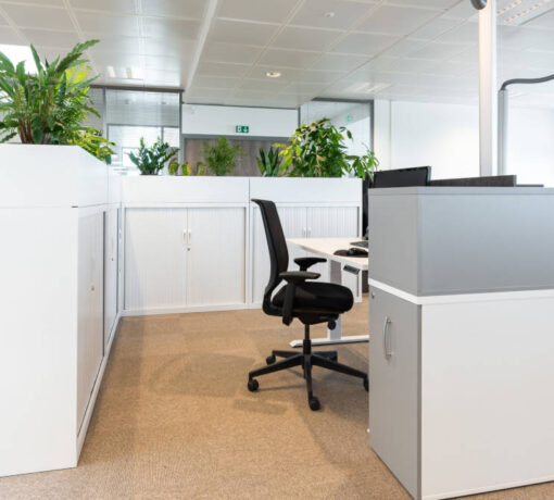 Bureau fermé autour de plantes top chez Dipra, aménagé avec un mobilier comprenant un bureau réglable en hauteur, un siège ergonomique, et des solutions de rangement, conçu pour des tâches nécessitant concentration et discrétion.