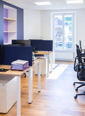 Espace de travail chez Léa Solidarité Femmes, montrant un agencement fonctionnel avec des bureaux individuels, des zones de travail collaboratif.