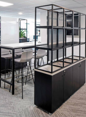 Espace de concentration aménagé avec des tables hautes, des tabourets et un séparateur Corral, créant un cadre de travail flexible et inspirant pour des sessions de travail intensives.
