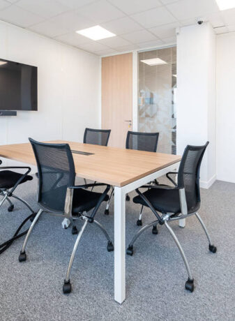 Espace de travail collaboratif chez le Leader Mondial de Production de Transducteurs, aménagé avec des tables U-DESK de réunion et des sièges confortables, permettant une flexibilité pour les projets d'équipe et les sessions de brainstorming.