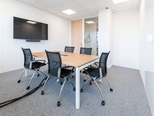 Espace de travail collaboratif chez le Leader Mondial de Production de Transducteurs, aménagé avec des tables U-DESK de réunion et des sièges confortables, permettant une flexibilité pour les projets d'équipe et les sessions de brainstorming.