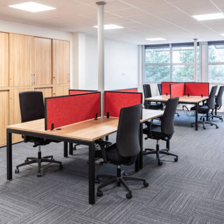 Espace de travail ouvert chez Ariston, montrant des bureaux U-DESK partagés, des cloisons acoustiques SILENS, pour encourager l'interaction entre les équipes.