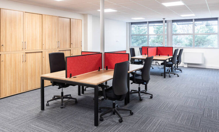 Espace de travail ouvert chez Ariston, montrant des bureaux U-DESK partagés, des cloisons acoustiques SILENS, pour encourager l'interaction entre les équipes.