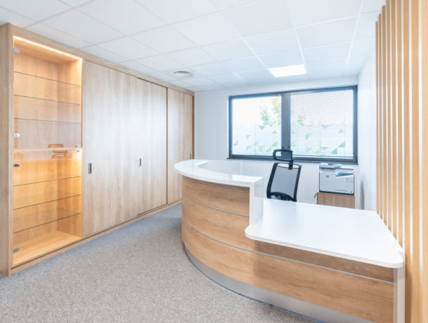 Zone d'accueil élégante présentant une banque d'accueil contemporaine accompagnée d'un siège ergonomique Récital, créant un environnement accueillant et professionnel.