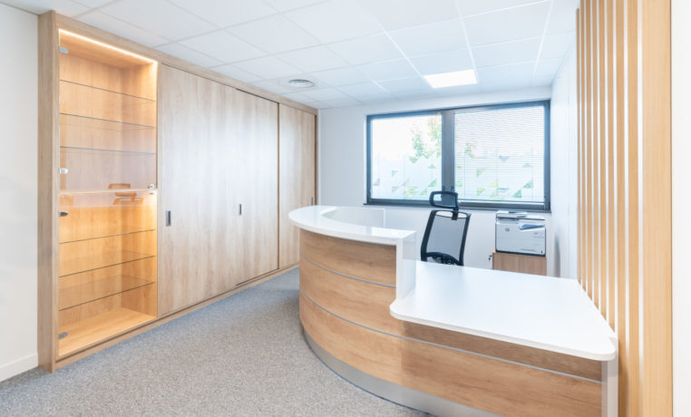Zone d'accueil élégante présentant une banque d'accueil contemporaine accompagnée d'un siège ergonomique Récital, créant un environnement accueillant et professionnel.