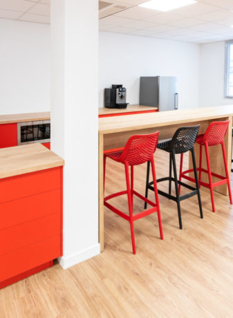 Espace café/réfectoire chez Ariston, comprenant des tables hautes Swarm élégantes et des tabourets confortables, idéal pour des pauses café et des moments de détente entre les collaborateurs.