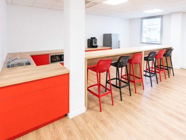 Espace café/réfectoire chez Ariston, comprenant des tables hautes Swarm élégantes et des tabourets confortables, idéal pour des pauses café et des moments de détente entre les collaborateurs.