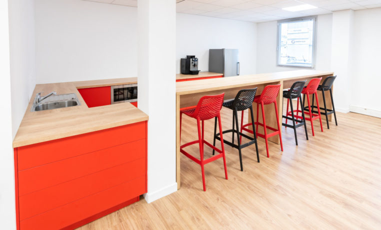 Espace café/réfectoire chez Ariston, comprenant des tables hautes Swarm élégantes et des tabourets confortables, idéal pour des pauses café et des moments de détente entre les collaborateurs.