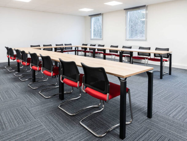 Salle de réunion chez Ariston, équipée d'une grande table de conférence entourée de chaises ergonomiques, créant un cadre idéal pour des réunions professionnelles et des présentations.