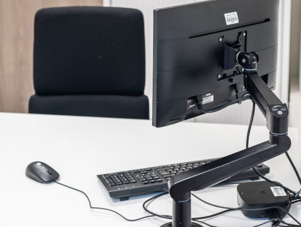 Bureau fermé chez Département du Rhône montrant le support écran monté sur le bureau, optimisant l'espace de travail et facilitant la gestion des équipements informatiques.