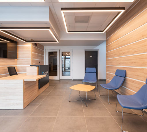 Banque d'accueil chez Carbogen Amcis, offrant un design moderne et fonctionnel pour accueillir les visiteurs avec un comptoir bien agencé et un espace d'attente confortable grâce aux fauteuils SILENCE.