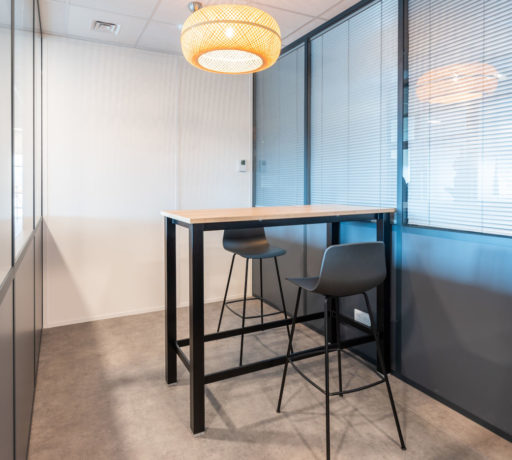 Espace de collaboration chez Carbogen Amcis, aménagé avec des tables hautes LINEA et des tabourets flexibles, conçu pour encourager les interactions créatives et le travail d'équipe.