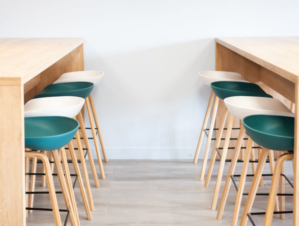 Réfectoire chez Carbogen Amcis, aménagé avec du mobilier moderne comprenant des tables haute SWARM et des tabourets élégantes aux couleurs de leur marque, offrant un espace convivial pour les pauses café et les repas informels.