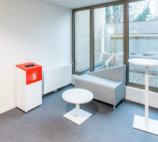 Espace de pause chez Département du Rhône aménagé avec un canapé confortable, une table basse Linéa, une table haute Linéa et un container poubelle, idéal pour les moments d'attente.