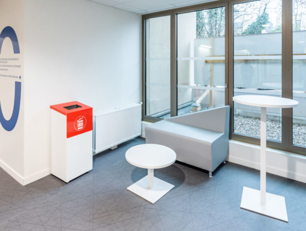 Espace de pause chez Département du Rhône aménagé avec un canapé confortable, une table basse Linéa, une table haute Linéa et un container poubelle, idéal pour les moments d'attente.