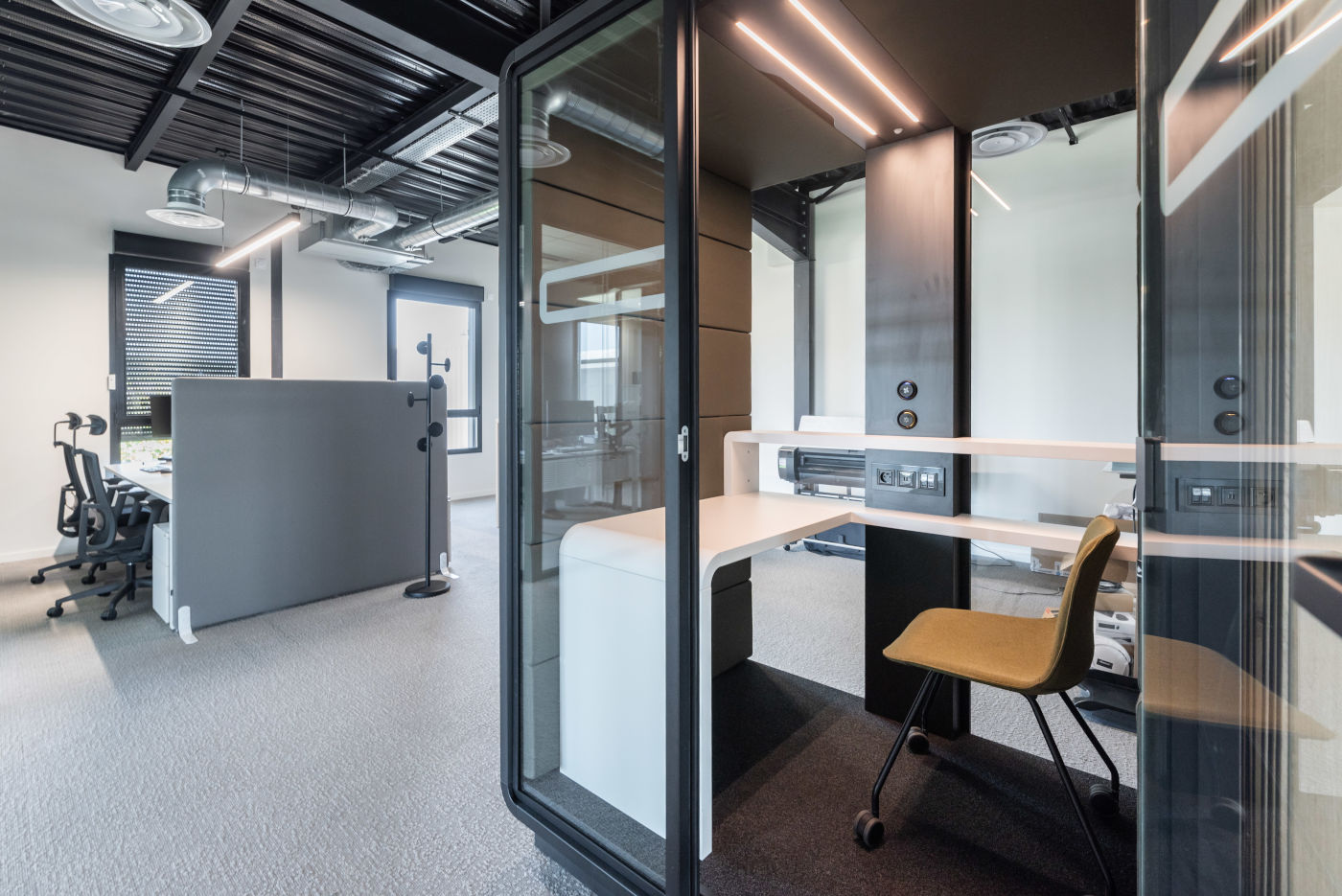 Cabine acoustique installée dans un environnement de bureau, illustrant son intégration harmonieuse et son efficacité pour réduire les nuisances sonores.