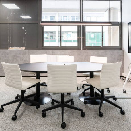 Table meeting spacieuse chez Ambition, placée à proximité d'un bureau individuel, idéale pour des réunions de groupe et des interactions professionnelles efficaces.