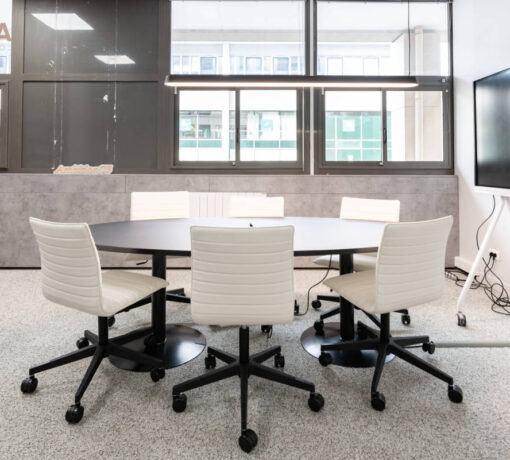 Table meeting spacieuse chez Ambition, placée à proximité d'un bureau individuel, idéale pour des réunions de groupe et des interactions professionnelles efficaces.
