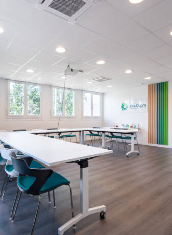 Salle de réunion chez Deltalys, aménagée avec des grandes tables à roulette et des chaises JOKY 4 pieds confortables, idéale pour les réunions d'équipe et les discussions stratégiques.