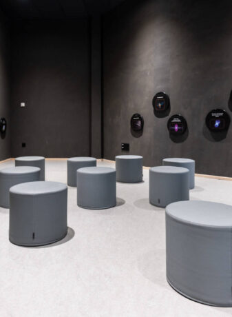 Espace d'attente chez Cosmocité, équipé de poufs Boom gris et confortables, créant un lieu informel et accueillant pour les visiteurs en attente.