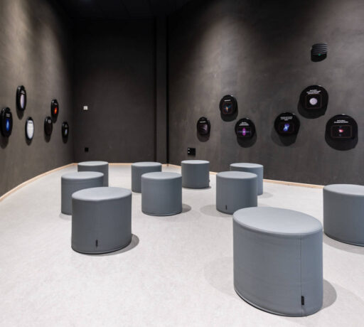 Espace d'attente chez Cosmocité, équipé de poufs Boom gris et confortables, créant un lieu informel et accueillant pour les visiteurs en attente.
