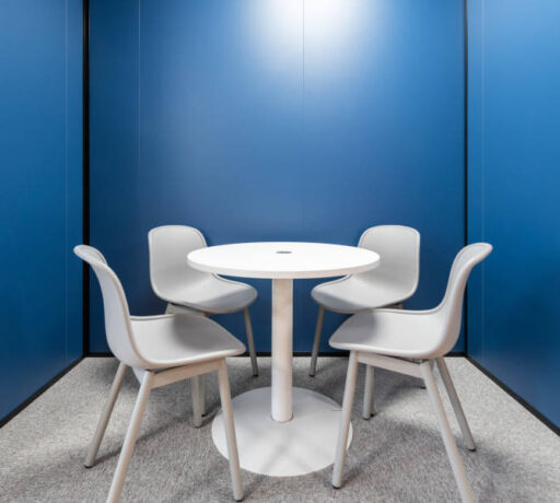 Salle de réunion intime chez Auvalie avec une table ronde, parfaite pour des discussions en petit groupe et des réunions de quatre personnes.