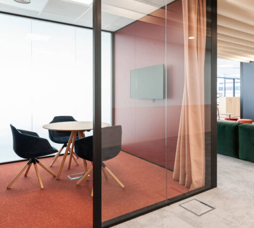 Petite salle de réunion équipée d'une table élégante entourée de trois fauteuils confortables, offrant un espace intime et professionnel pour des discussions en petit comité.