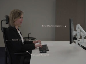 Personne assise correctement à son bureau : dos contre le dossier du siège, avant-bras formant un angle de 90° par rapport au corps, écran d'ordinateur placé droit devant les yeux à hauteur confortable.