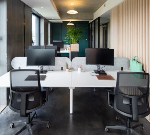 Open space avec des postes de travail : bureaux et sièges à roulettes ergonomiques