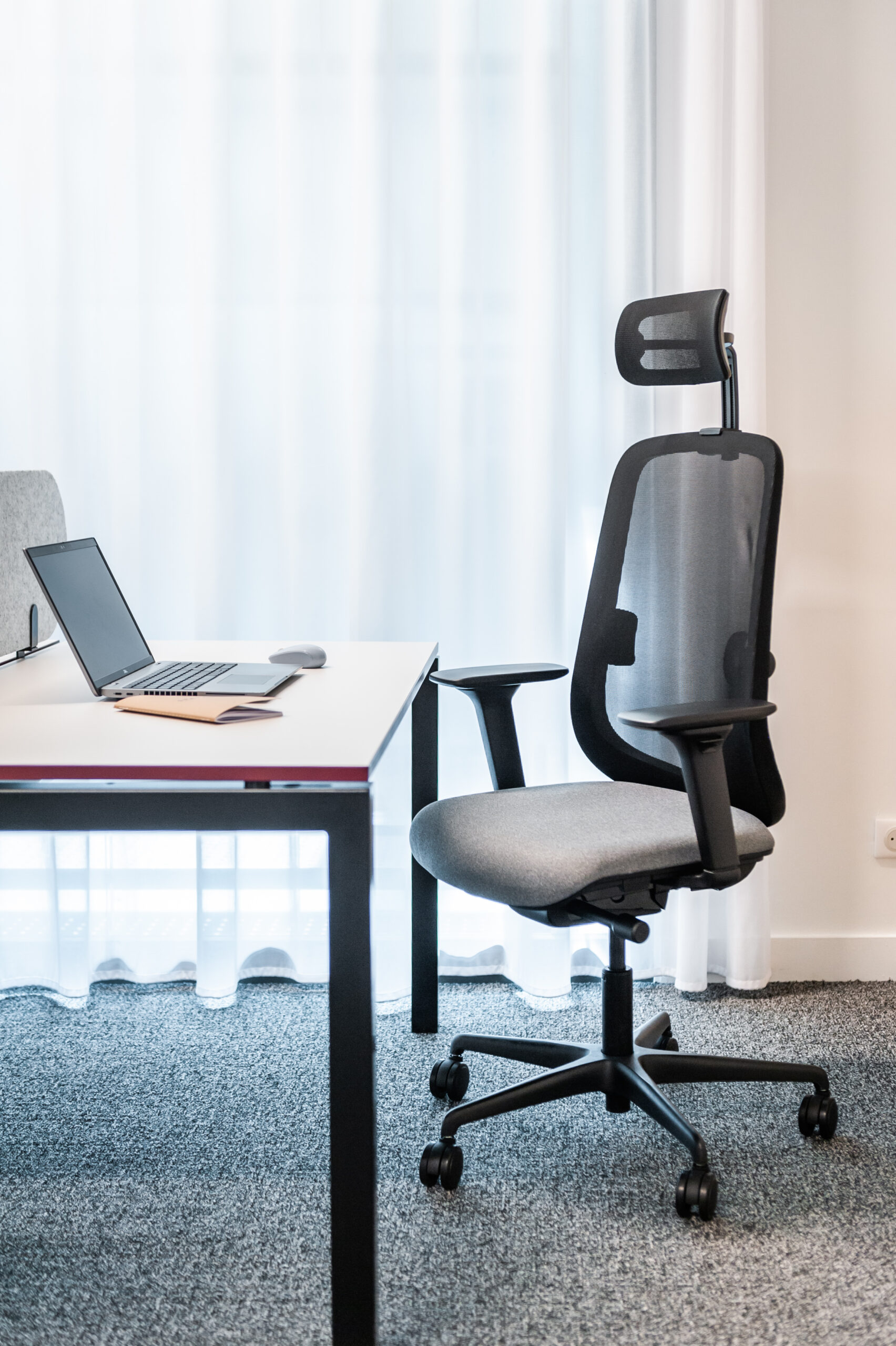 fauteuil ergonomique YULI en situation dans un open space, devant un bureau U-desk SPARK