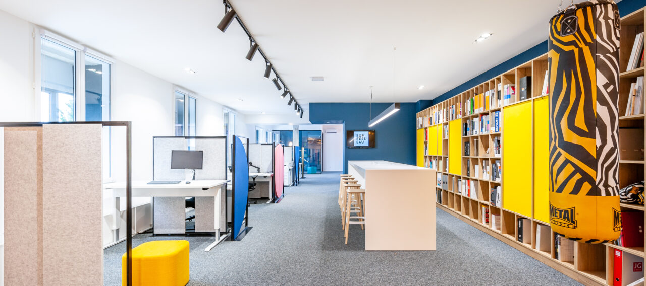 Open space avec bibliothèque et punching-ball au siège Spark Office à Saint-Agrève